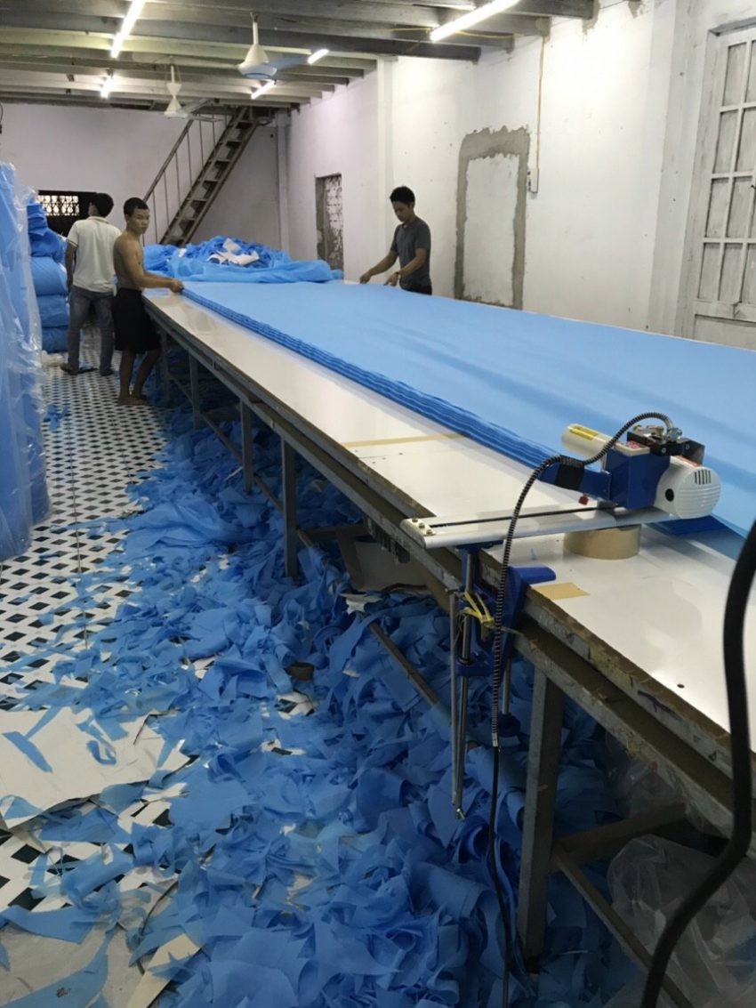 Công nhân cắt vải may đồ bảo hộ Y tế